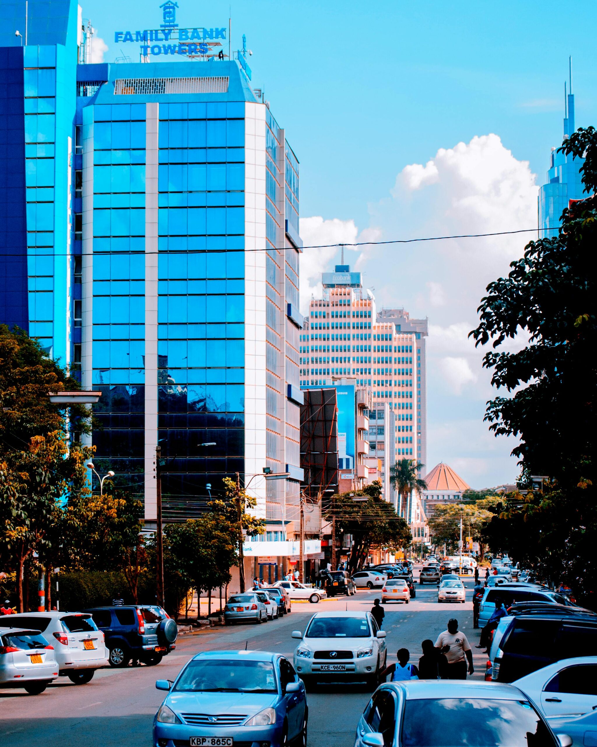 Dynamic cityscape showcasing modern skyscrapers and bustling urban life on a sunny day.